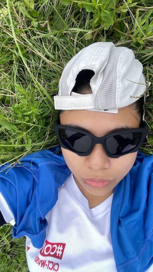 April lying on the grass with sunglasses after a hike