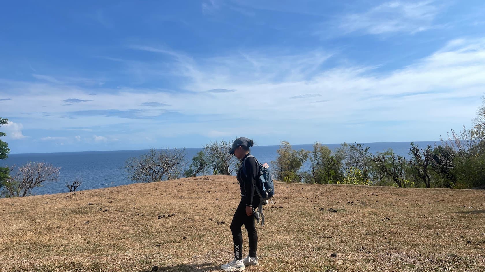 April standing on a cliff overlooking the ocean while hiking